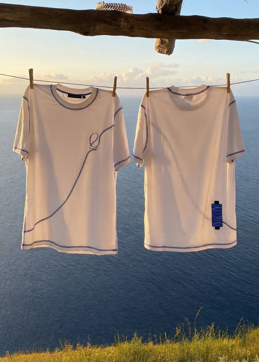 T-shirt A bobina avec bobine imprimée et logo, face au coucher de soleil sur la mer de l’Algarve. Marques, une marque faite pour vous faire voyager